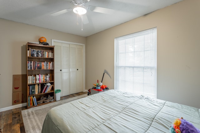 bedroom featuring a closet, hardwood / wood-style floors, a textured ceiling, and ceiling fan