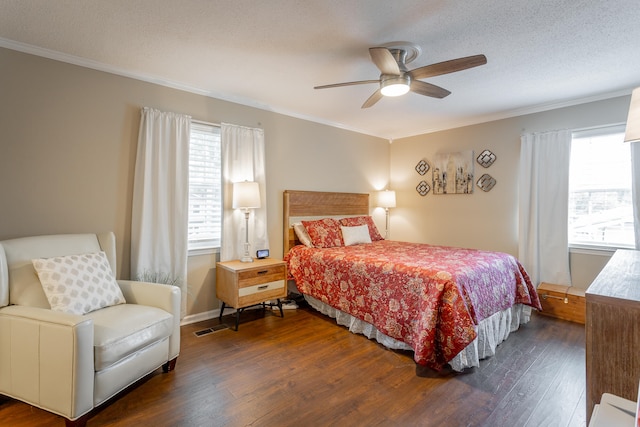 bedroom featuring ceiling fan, ornamental molding, dark wood-type flooring, and multiple windows