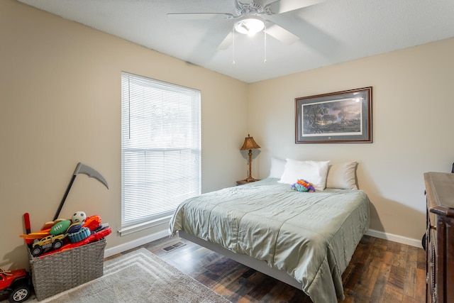 bedroom featuring ceiling fan, dark hardwood / wood-style flooring, and multiple windows