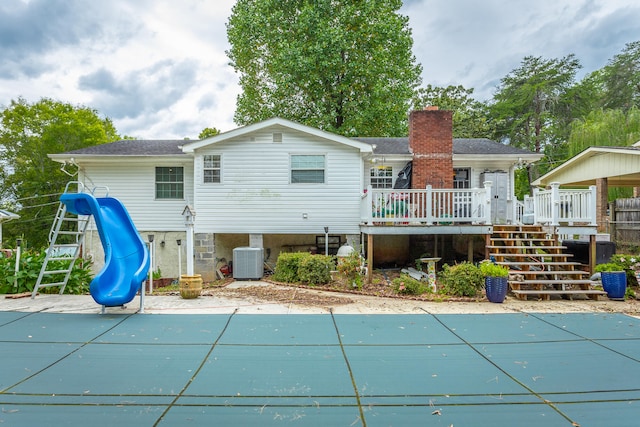 rear view of house with central air condition unit and a swimming pool side deck