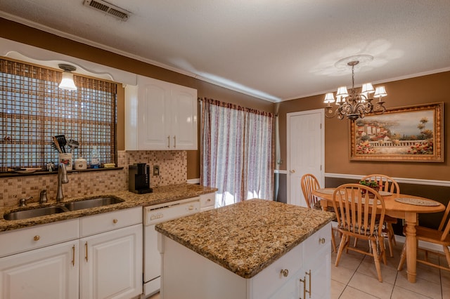 kitchen featuring sink, dishwasher, hanging light fixtures, ornamental molding, and white cabinetry