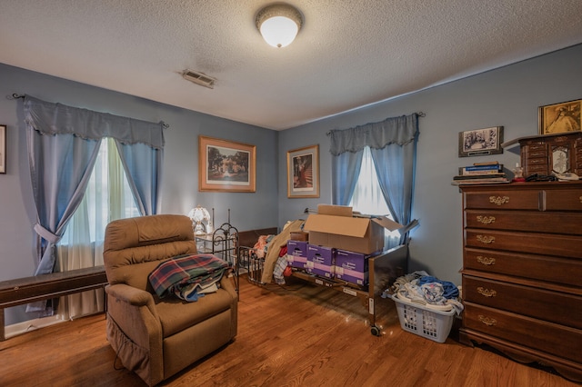 sitting room with hardwood / wood-style flooring and a textured ceiling