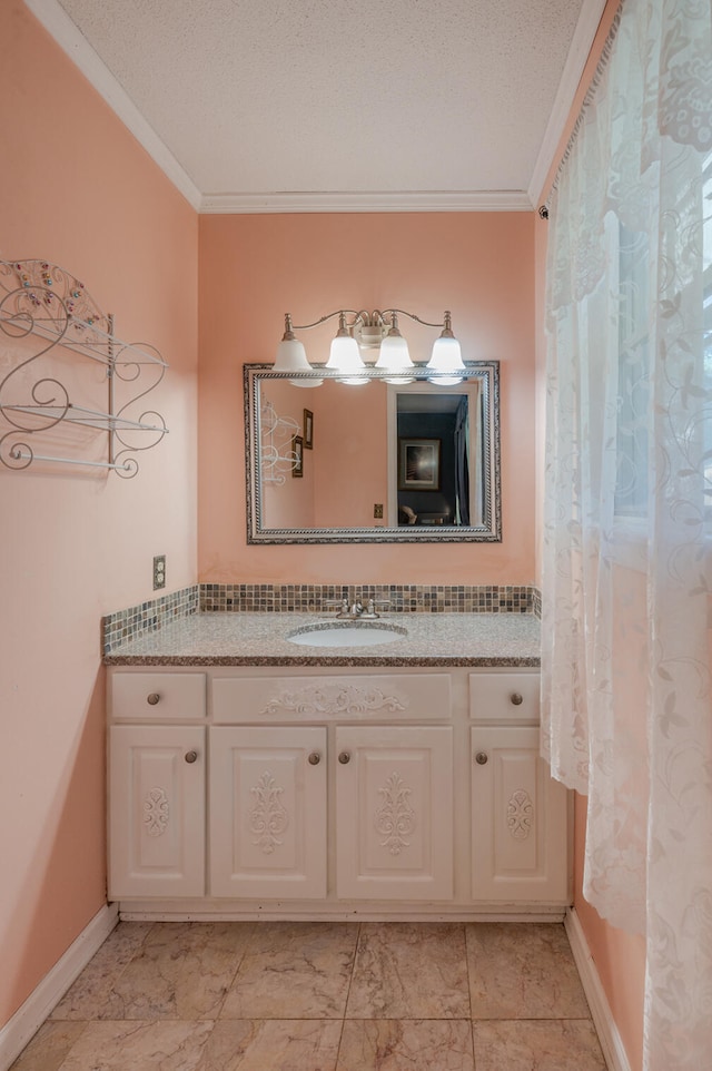 bathroom featuring ornamental molding, vanity, and a textured ceiling