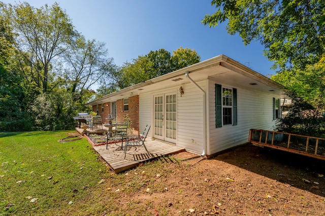 rear view of property featuring a yard and a wooden deck