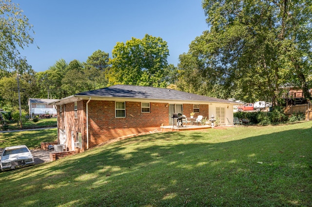 rear view of property with a patio and a yard