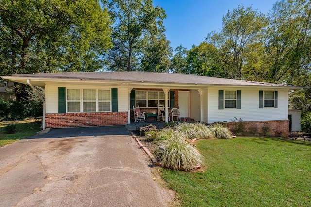 ranch-style house featuring covered porch and a front yard