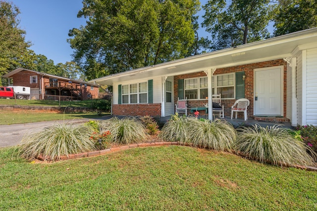 ranch-style home with a porch and a front yard