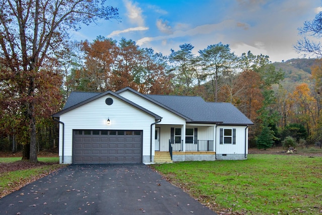 view of front of property featuring a garage, a front lawn, and a porch