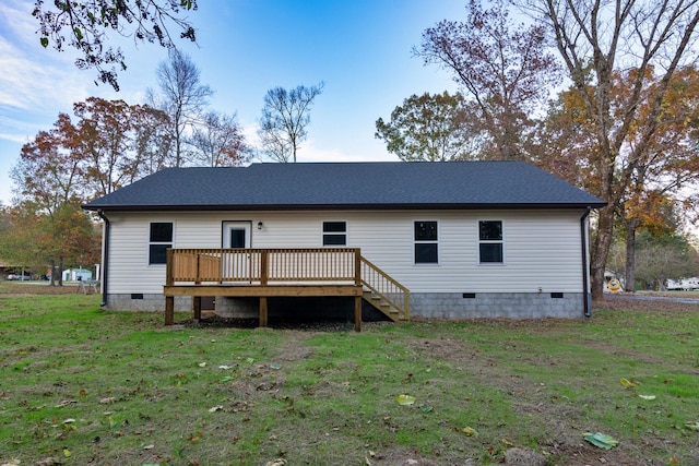 rear view of property with a wooden deck and a lawn