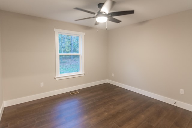 spare room with ceiling fan and dark wood-type flooring