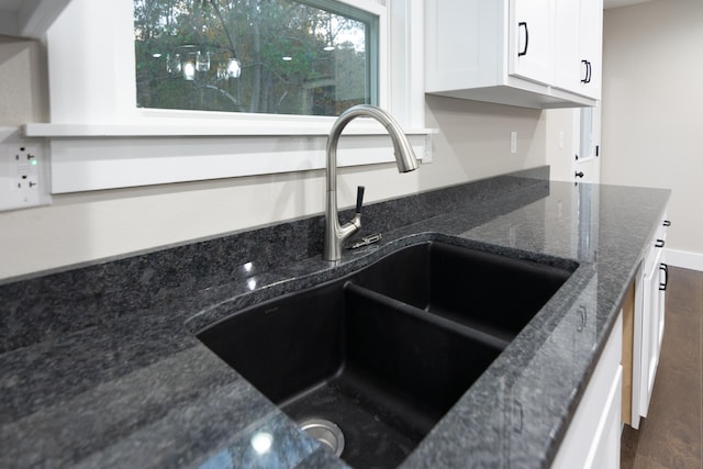 kitchen with sink, white cabinetry, dark hardwood / wood-style floors, and dark stone countertops