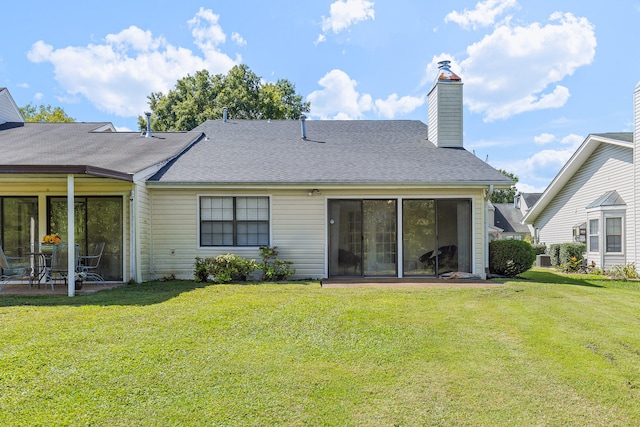 rear view of house featuring a lawn and a patio