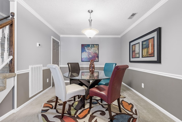 carpeted dining space with a textured ceiling and crown molding