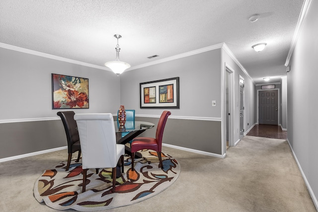 dining space with carpet floors, crown molding, and a textured ceiling