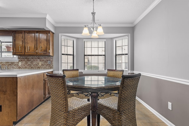 tiled dining area with an inviting chandelier, a textured ceiling, a healthy amount of sunlight, and crown molding