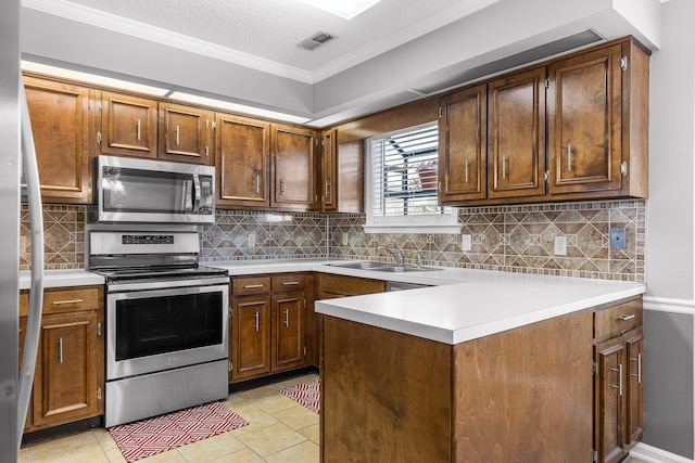 kitchen featuring a textured ceiling, tasteful backsplash, sink, appliances with stainless steel finishes, and light tile patterned floors