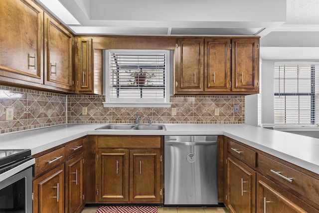 kitchen with backsplash, stainless steel dishwasher, and sink