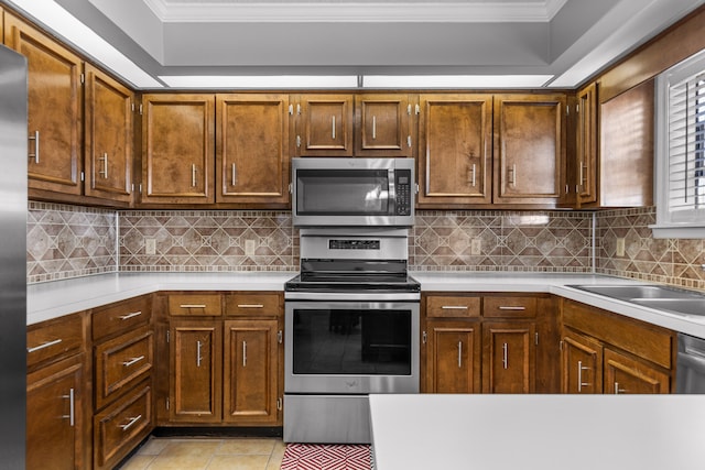 kitchen with ornamental molding, stainless steel appliances, and tasteful backsplash