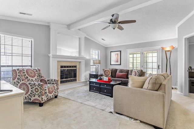 carpeted living room with lofted ceiling with beams, ceiling fan, a textured ceiling, and a healthy amount of sunlight