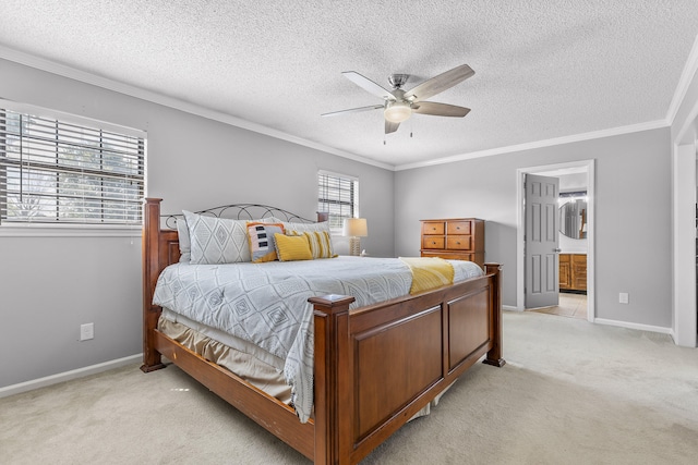 bedroom with a textured ceiling, light colored carpet, ensuite bathroom, crown molding, and ceiling fan