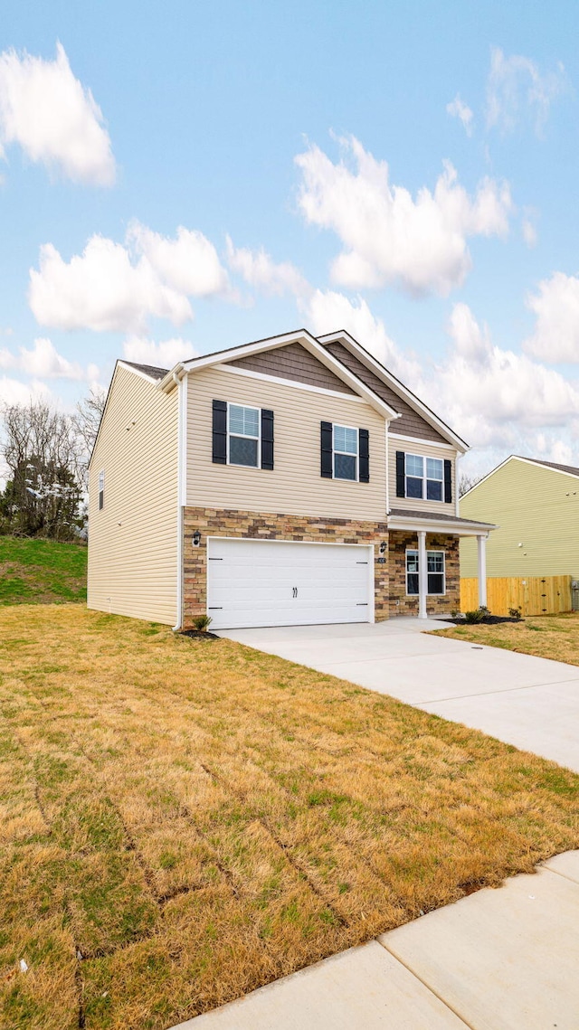 view of front of home featuring a garage, concrete driveway, and a front lawn