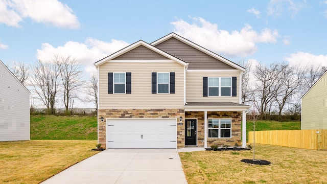 view of front of property with driveway, stone siding, fence, a front yard, and a garage