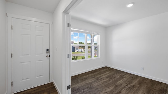 foyer featuring dark wood-type flooring and baseboards