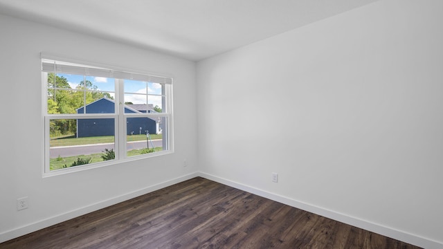 empty room with dark wood-style floors and baseboards