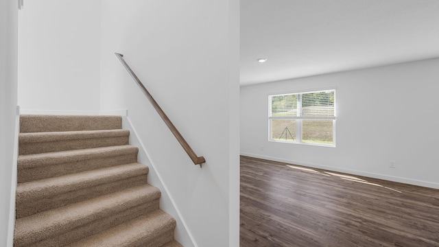 staircase with recessed lighting, baseboards, and wood finished floors