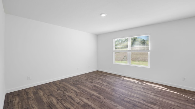 spare room with dark wood-style floors and baseboards