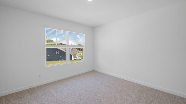 empty room featuring baseboards and carpet flooring