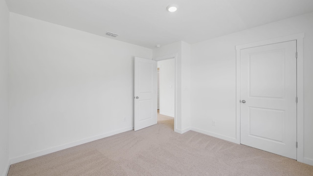 unfurnished bedroom with recessed lighting, light colored carpet, visible vents, and baseboards