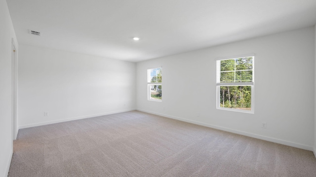 unfurnished room featuring recessed lighting, visible vents, light colored carpet, and baseboards