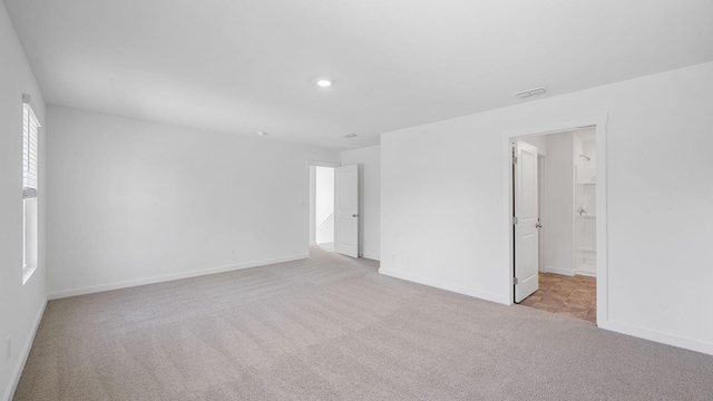 carpeted empty room with visible vents, recessed lighting, and baseboards