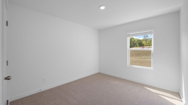 unfurnished room with carpet flooring and baseboards