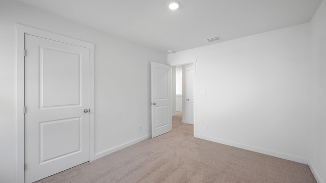 unfurnished bedroom with visible vents, baseboards, and carpet