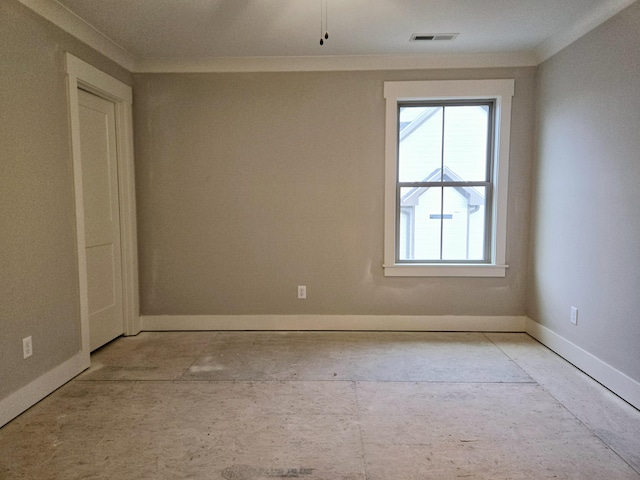 spare room featuring baseboards, visible vents, and crown molding