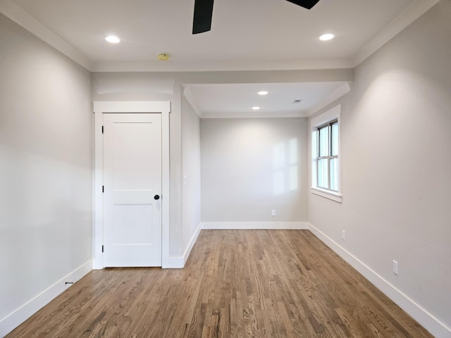 empty room featuring ornamental molding, recessed lighting, baseboards, and wood finished floors