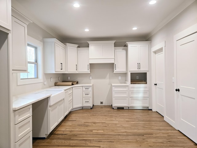 kitchen with light wood finished floors, white cabinets, and recessed lighting