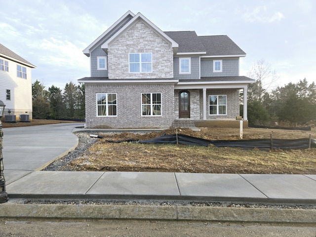 craftsman-style home featuring central AC and stone siding