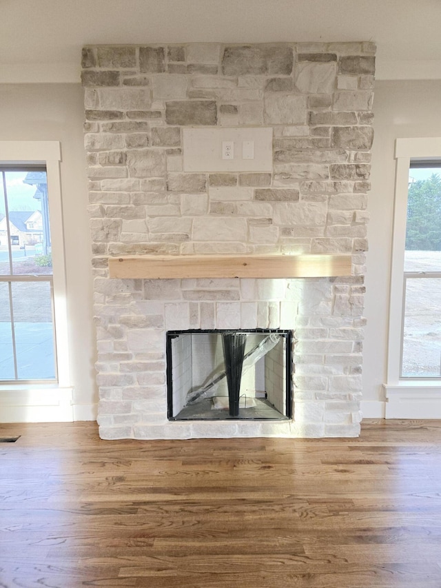 details with visible vents, a fireplace, and wood finished floors