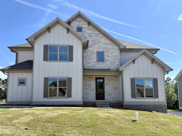modern inspired farmhouse featuring a shingled roof, board and batten siding, stone siding, and a front yard