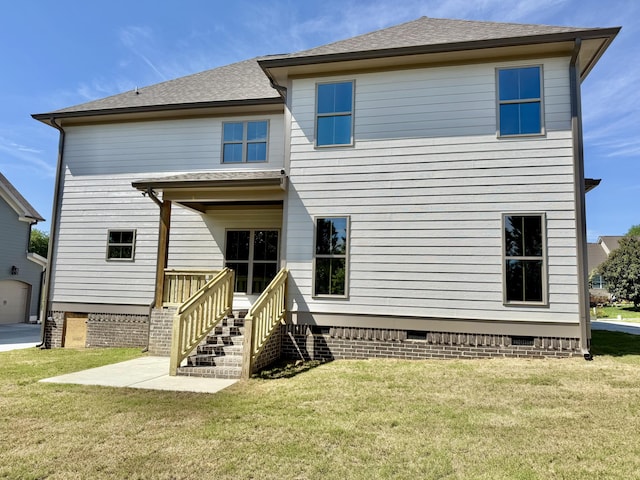 rear view of house featuring a lawn, crawl space, and roof with shingles