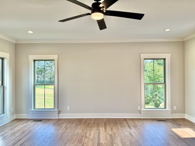 empty room featuring crown molding, wood finished floors, and visible vents