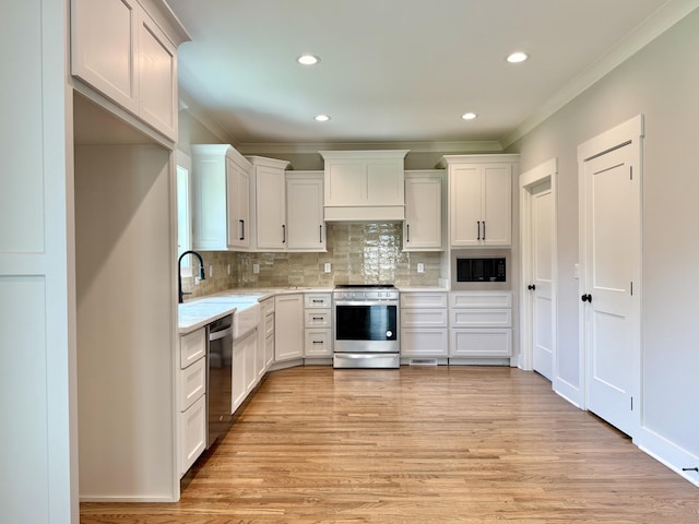 269 Quartz Dr Unit 21, Chickamauga, GA 30707 - kitchen featuring appliances with stainless steel finishes, ornamental molding, decorative backsplash, light wood finished floors, and white cabinets