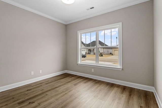 empty room featuring crown molding and hardwood / wood-style flooring