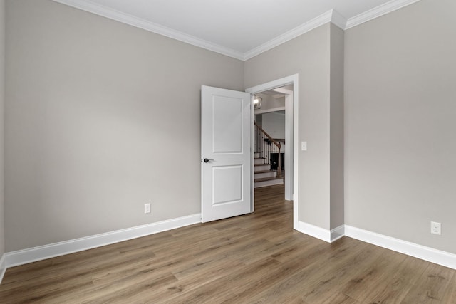 unfurnished room with hardwood / wood-style flooring and ornamental molding