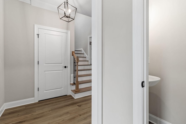 stairs with hardwood / wood-style flooring and a chandelier