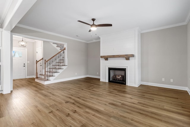 unfurnished living room featuring a fireplace, hardwood / wood-style floors, ceiling fan with notable chandelier, and ornamental molding