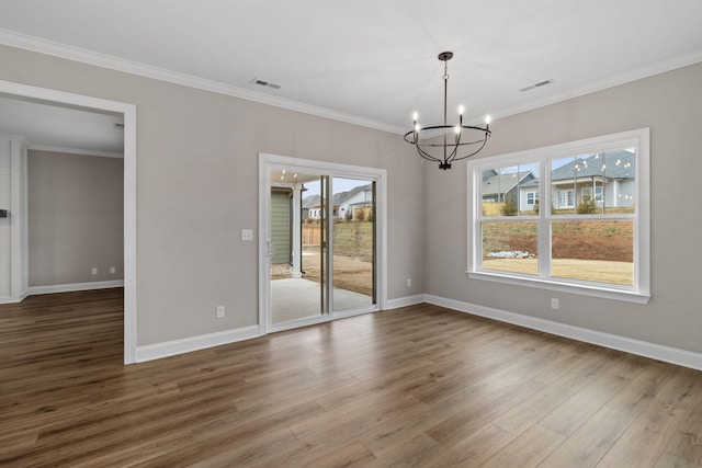 unfurnished dining area with hardwood / wood-style floors, crown molding, and a chandelier